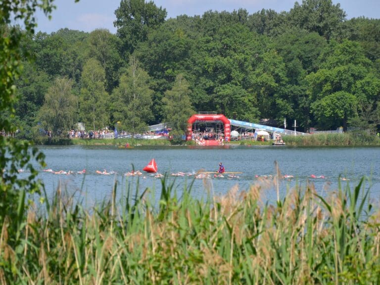 Seitenblick von der Laufstrecke - im Baggersee sind die Starter der Olympischen Distanz unterwegs