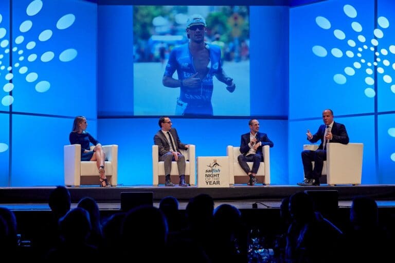 Der Sport1-Mann ließt sich von Patrick Lange dessen schwammbestückten "Maschinenraum" im Trisuit erklären ...